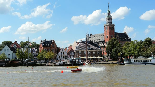Detektive ermitteln am Ufer der Leda mit Blick auf das Rathaus von Leer.